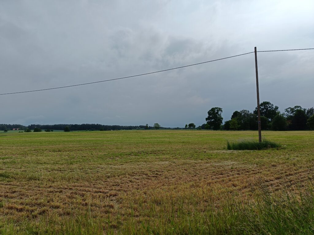słup energetyczny na polu, niebieskie niebo